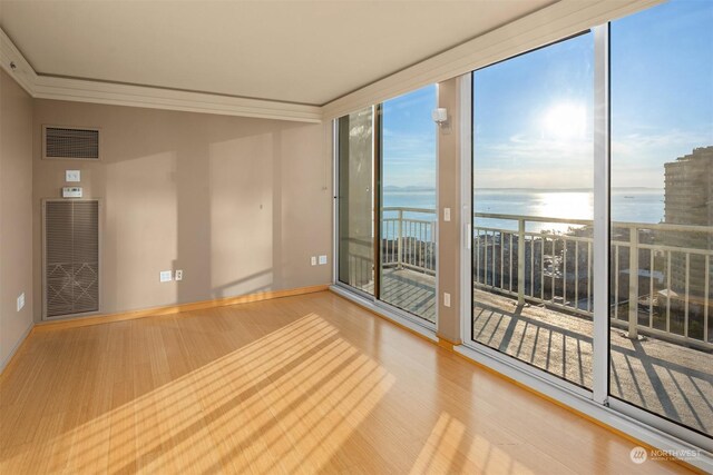 spare room with a water view and wood-type flooring