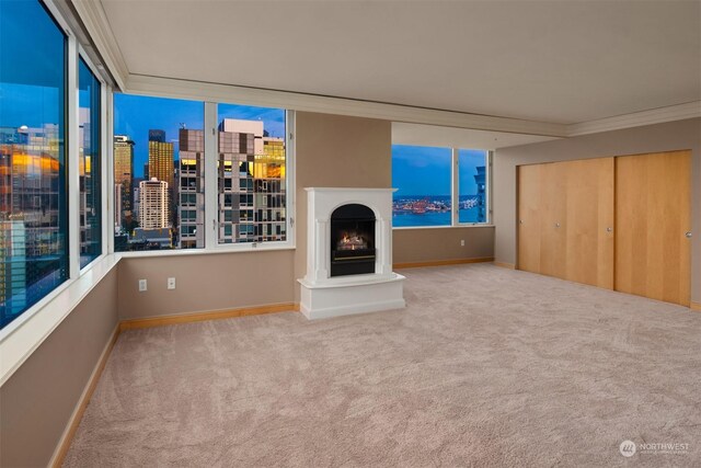 unfurnished living room featuring carpet and ornamental molding