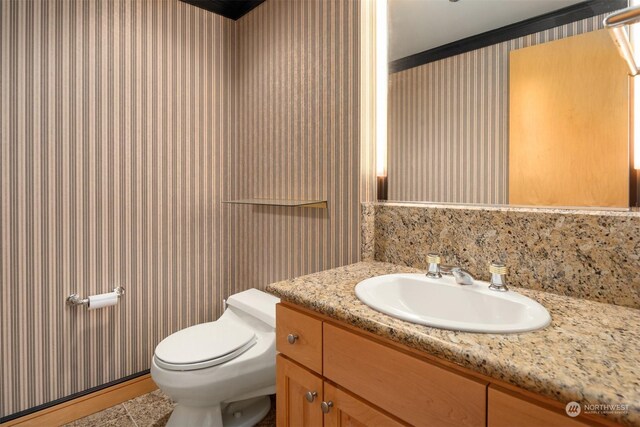 bathroom featuring tile patterned floors, vanity, toilet, and crown molding