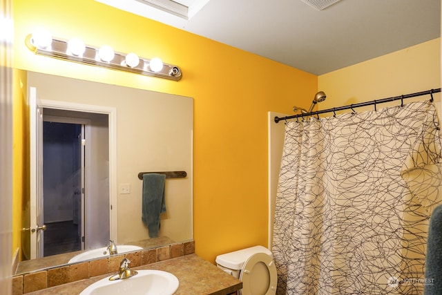 bathroom with curtained shower, vanity, and toilet