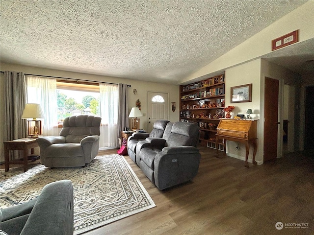 living room with hardwood / wood-style flooring, a textured ceiling, and lofted ceiling