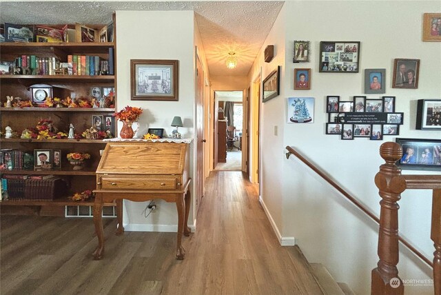 hall featuring hardwood / wood-style flooring and a textured ceiling