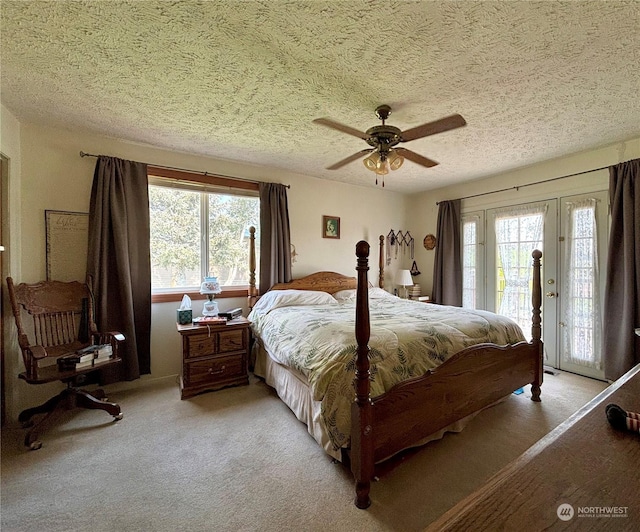 carpeted bedroom featuring ceiling fan, access to outside, multiple windows, and a textured ceiling