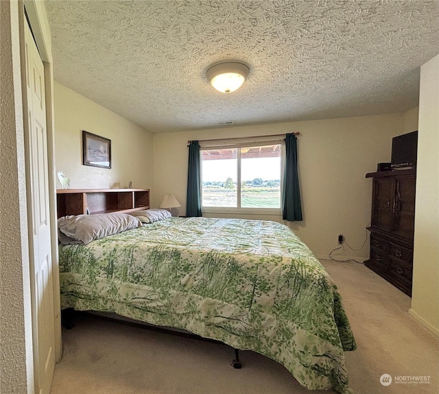 carpeted bedroom featuring a textured ceiling