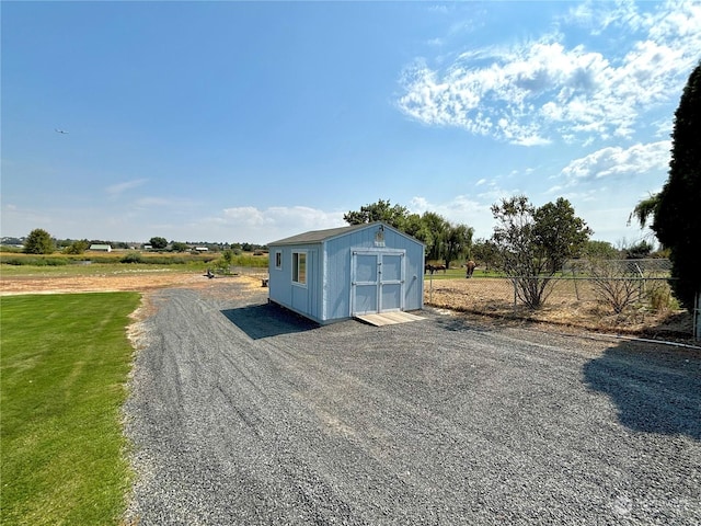 view of outdoor structure with a rural view and a lawn