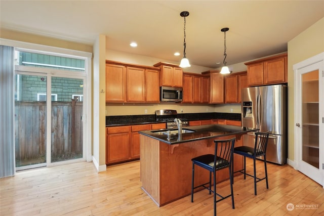 403 N I St, Tacoma, WA 98403 - kitchen with brown cabinets, appliances with stainless steel finishes, dark countertops, and light wood finished floors