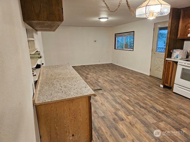 kitchen with white electric stove, dark hardwood / wood-style floors, pendant lighting, and light stone counters