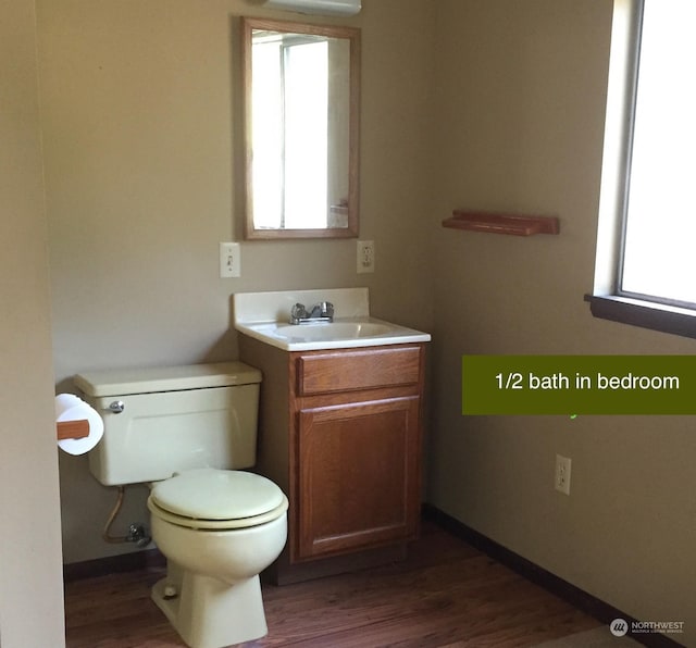 bathroom featuring wood-type flooring, toilet, and vanity