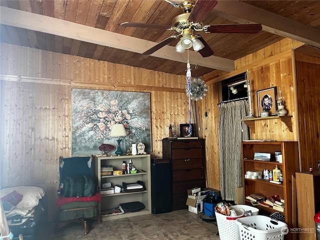 interior space featuring wood walls, wood ceiling, a ceiling fan, and beam ceiling