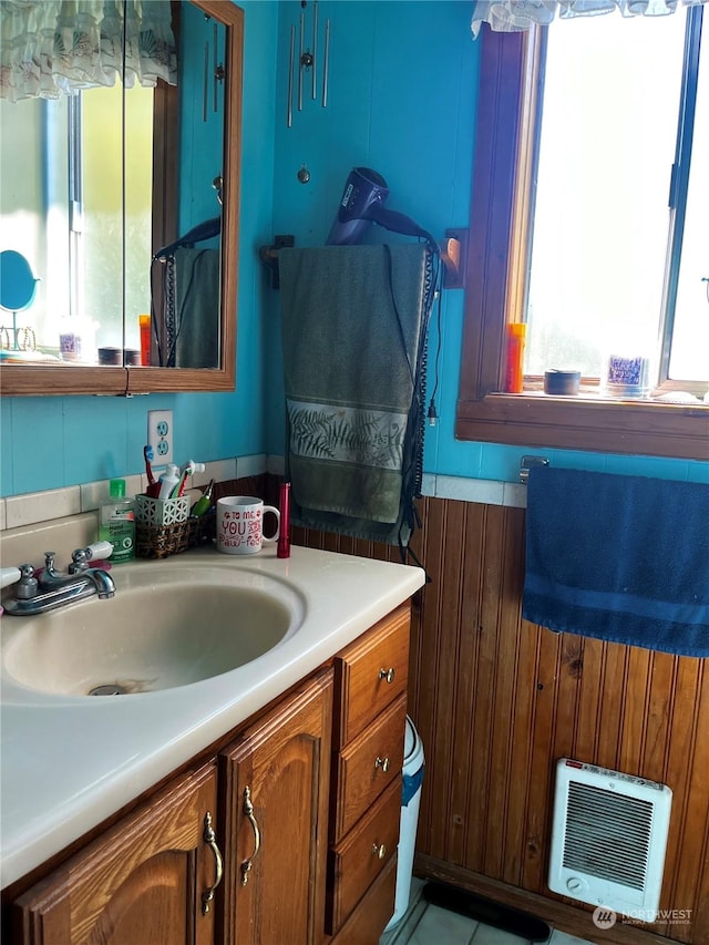 bathroom featuring heating unit and vanity