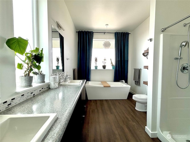 full bathroom featuring plus walk in shower, vanity, toilet, and hardwood / wood-style floors