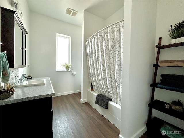 bathroom with hardwood / wood-style flooring, vanity, and shower / bath combo