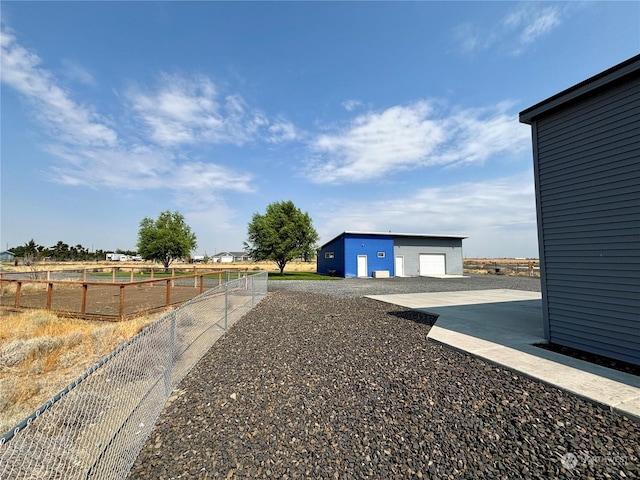 view of yard with a garage and an outbuilding