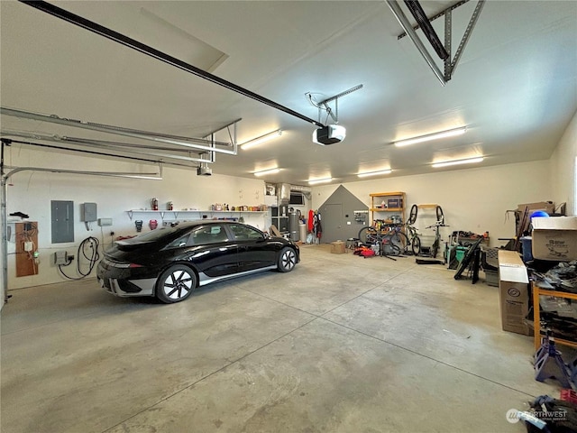 garage with a garage door opener and electric panel