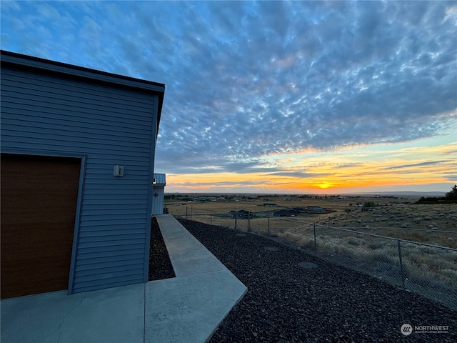 yard at dusk featuring a garage