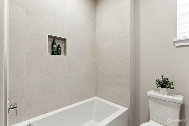 bathroom with tiled shower / bath and toilet