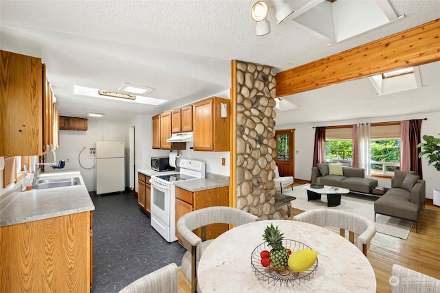 kitchen featuring white appliances, a textured ceiling, and sink