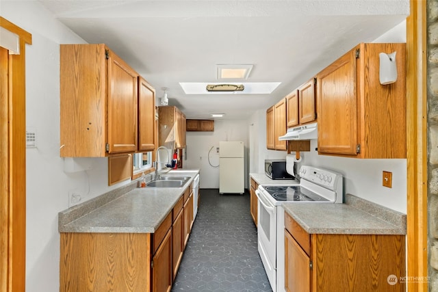 kitchen with a skylight, sink, and white appliances