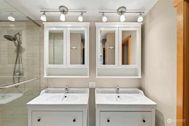 bathroom with a tile shower and vanity