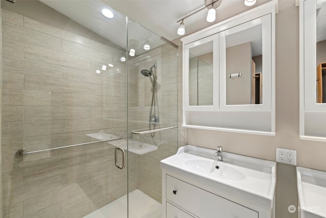 bathroom featuring vaulted ceiling, a shower with door, and vanity