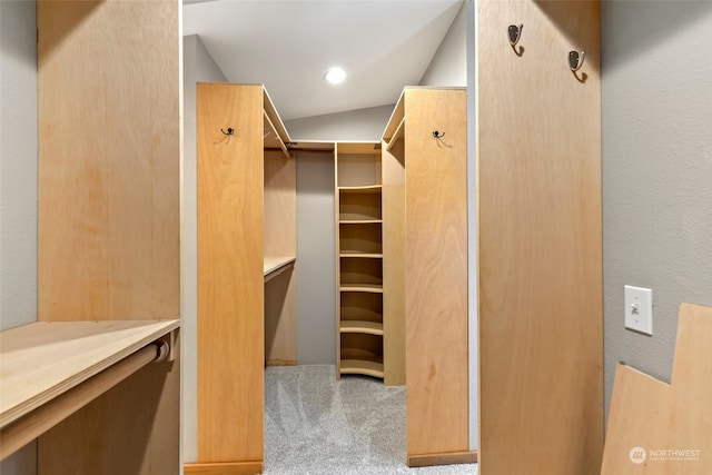 walk in closet with lofted ceiling and carpet floors