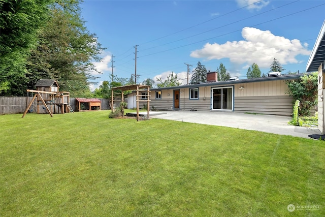 back of property featuring a lawn, a storage shed, a patio area, and a playground