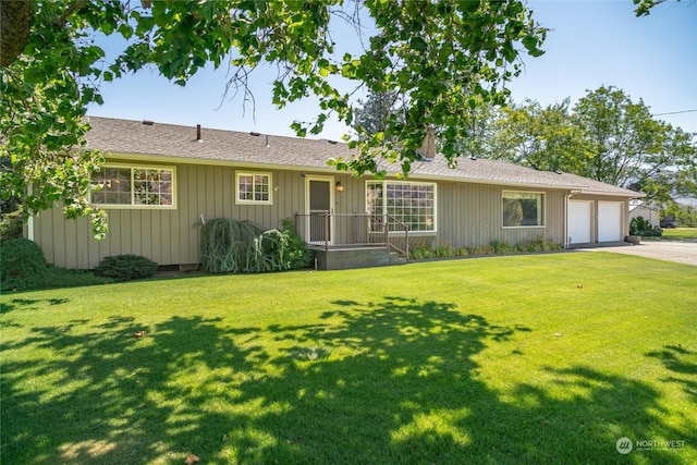 ranch-style house featuring a garage, concrete driveway, board and batten siding, and a front lawn