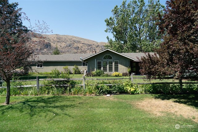 exterior space with a front yard, a mountain view, and fence