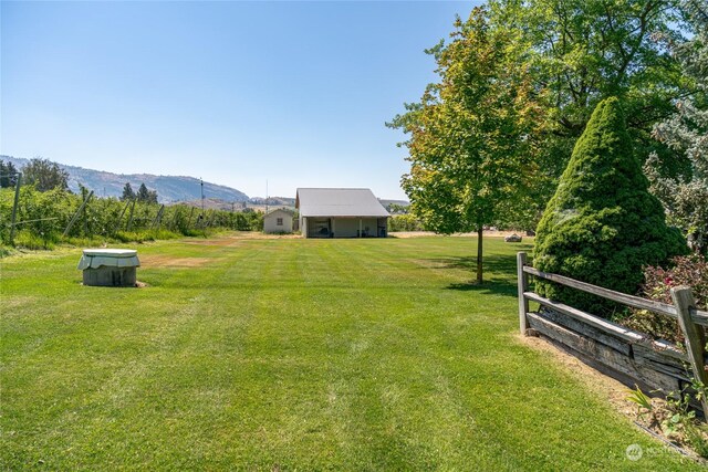 view of yard featuring a mountain view and fence