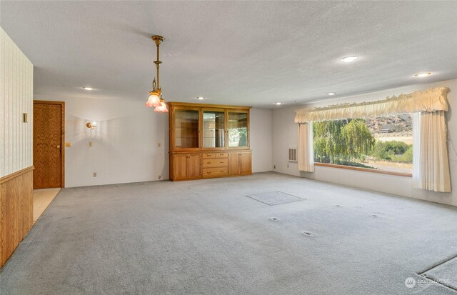 unfurnished living room featuring recessed lighting, a textured ceiling, and light colored carpet