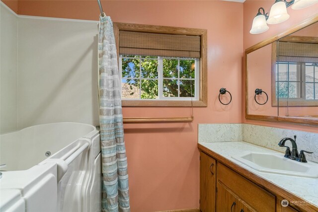 full bath featuring a bathtub and vanity