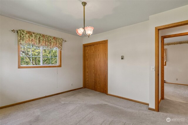 unfurnished room featuring baseboards and light colored carpet