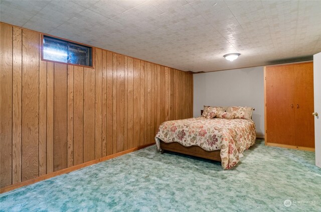 bedroom featuring carpet floors, wooden walls, and baseboards