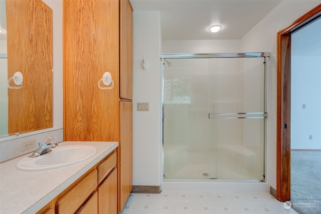 bathroom with tile patterned flooring, a shower with door, and vanity