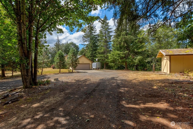 view of yard with a garage and an outbuilding