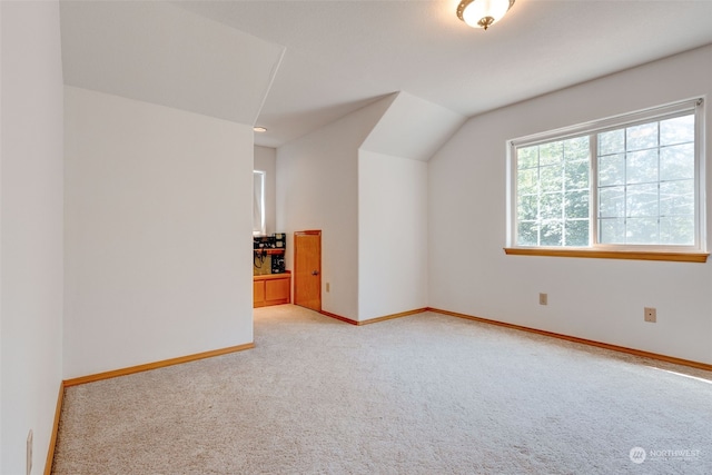 additional living space with vaulted ceiling and light colored carpet