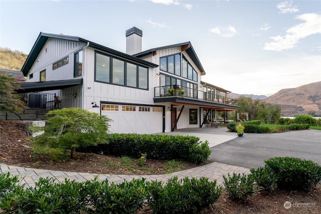 view of side of property featuring cooling unit, a mountain view, and a garage