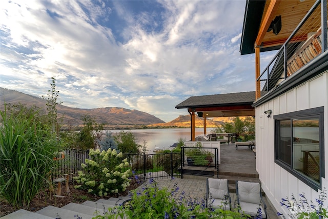 view of patio / terrace with a water and mountain view