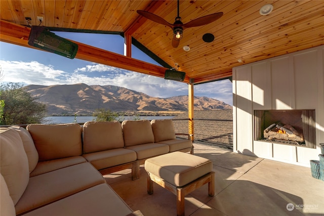 view of patio / terrace with a mountain view, an outdoor living space with a fireplace, and ceiling fan