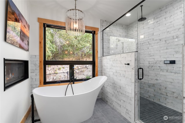 bathroom with plus walk in shower, tile patterned flooring, and a chandelier