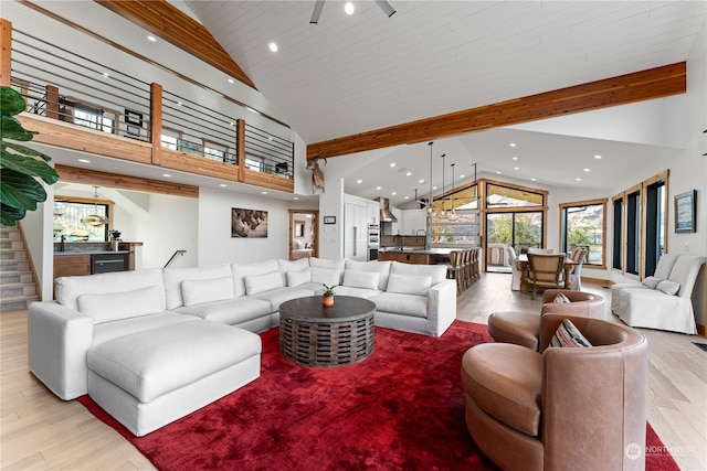 living room featuring high vaulted ceiling, hardwood / wood-style flooring, and beamed ceiling