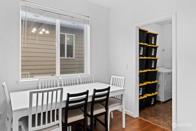 dining room with independent washer and dryer, dark wood-type flooring, and a healthy amount of sunlight