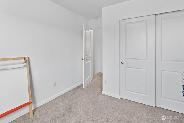 unfurnished bedroom featuring a closet and light carpet