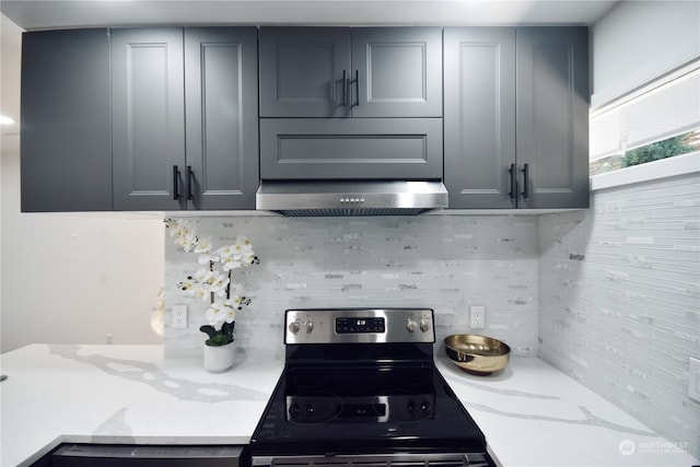 kitchen featuring gray cabinets, light stone countertops, and stainless steel range with electric cooktop