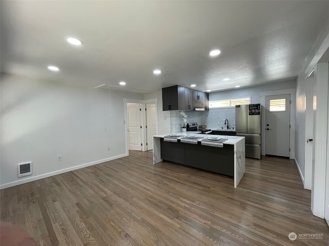 kitchen with gray cabinetry, stainless steel appliances, sink, dark hardwood / wood-style floors, and decorative backsplash