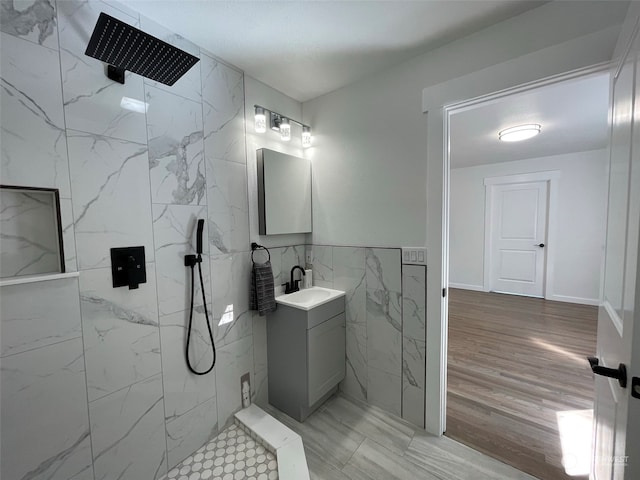 bathroom featuring vanity, tile walls, a tile shower, and hardwood / wood-style floors