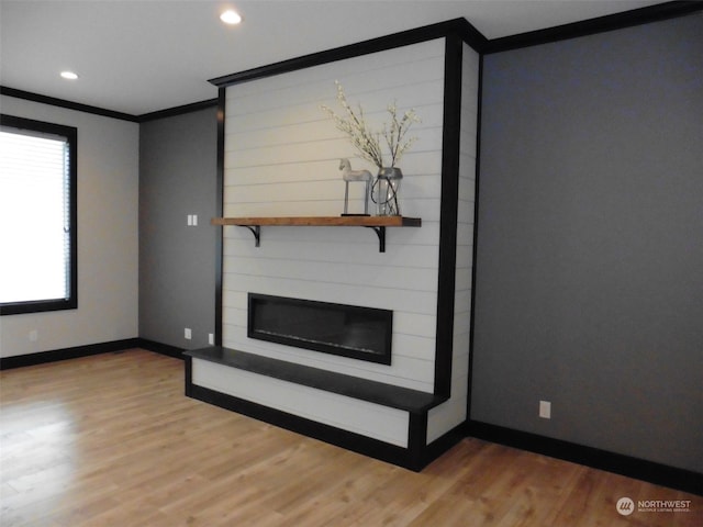 unfurnished living room featuring a fireplace, light wood-type flooring, and ornamental molding