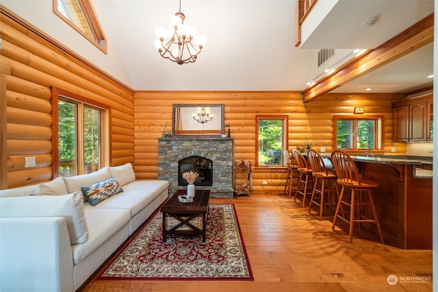 living room featuring light wood-type flooring, log walls, a fireplace, high vaulted ceiling, and a chandelier