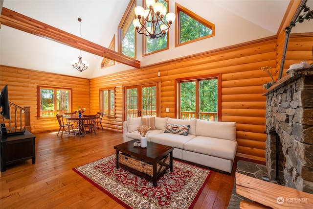 living room featuring high vaulted ceiling, rustic walls, and a chandelier