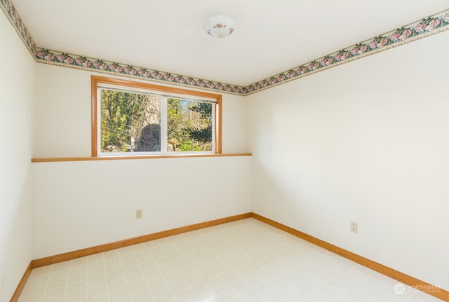 unfurnished room featuring light floors and baseboards